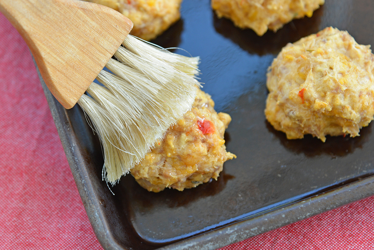 pastry brush adding butter to sausage balls