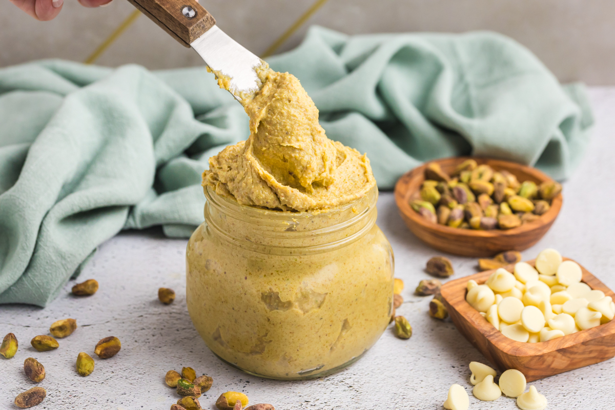 knife dipping into jar of pistachio cream